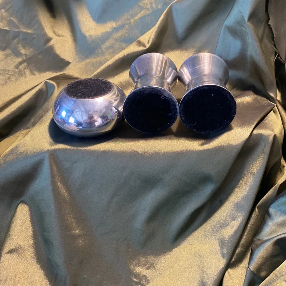 Three silvertone candleholders.